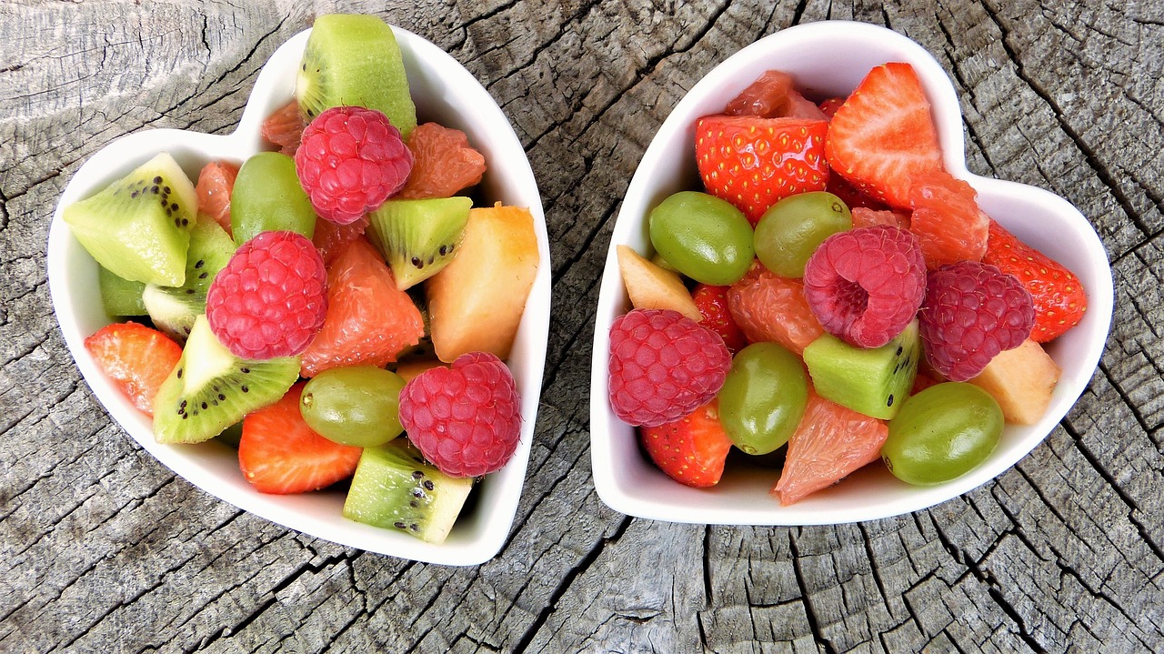 two heart-shaped bowls filled with fresh fruit