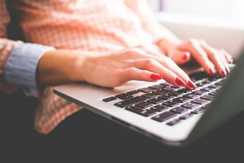 woman's hands typing on a laptop computer