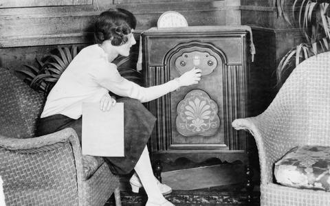 woman tuning radio in 1920s