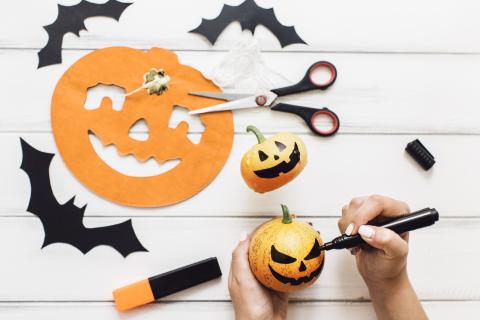 person crafting Halloween pumpkins