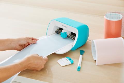 A person using a Cricut Joy machine.