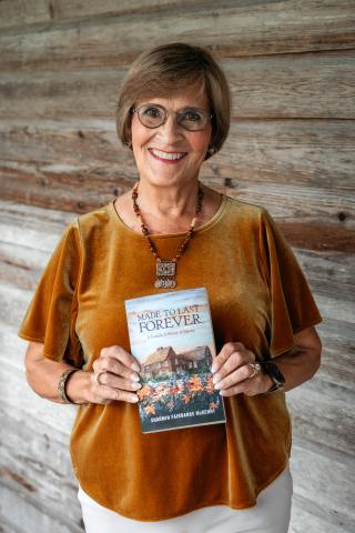 Author Sharmin McKenny holding her book “Made to Last Forever: A Family. A House. A Nation