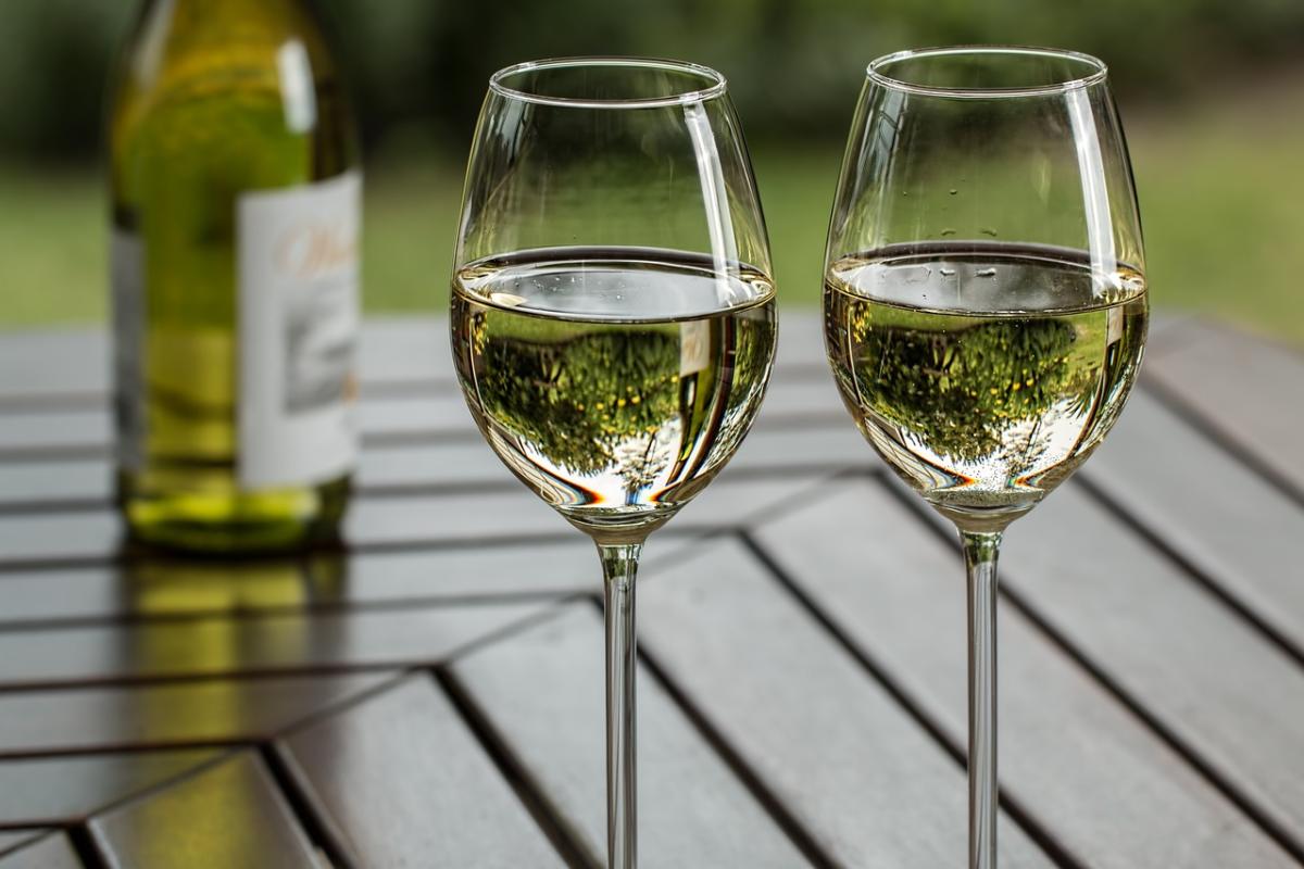 two glasses of white wine on a table