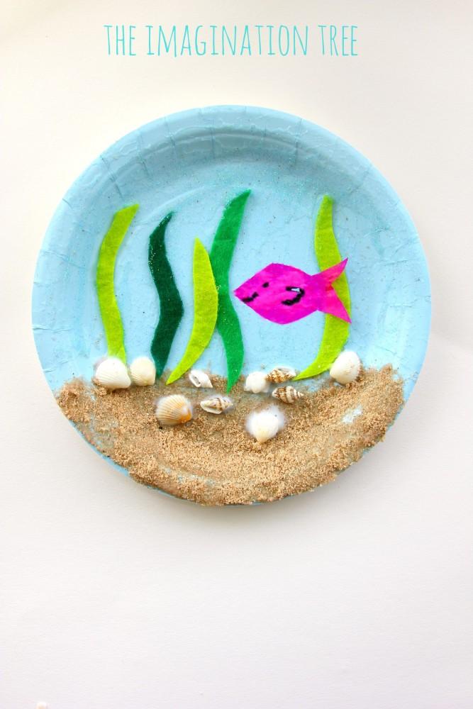 Paper plate craft with seaweed, sand and a fish