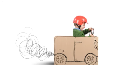 Child driving a cardboard box car